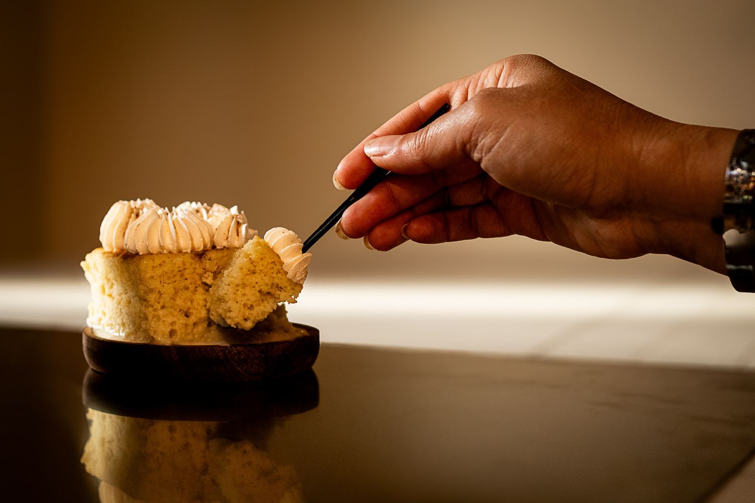 A hand lifting a soaked bite of Cloud Milk cake with a fork