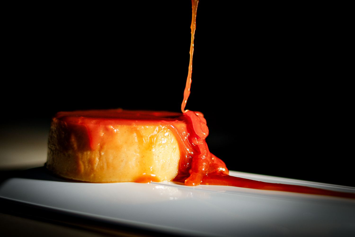 Coral Cream coconut flan under a pour of coral caramel
