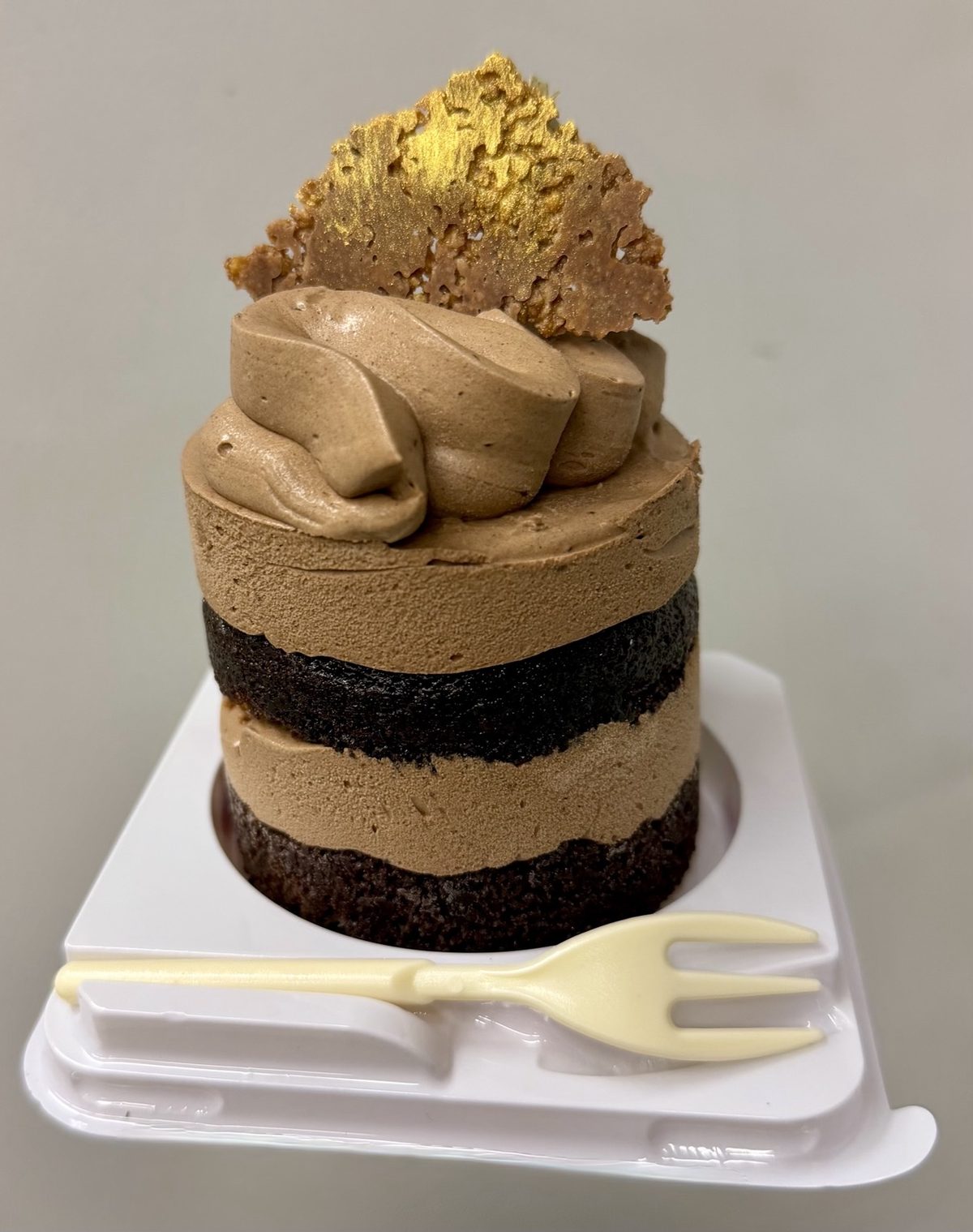 Sibu's Cake, dark chocolate layers with chocolate cream and a gold-dusted brittle shard on top